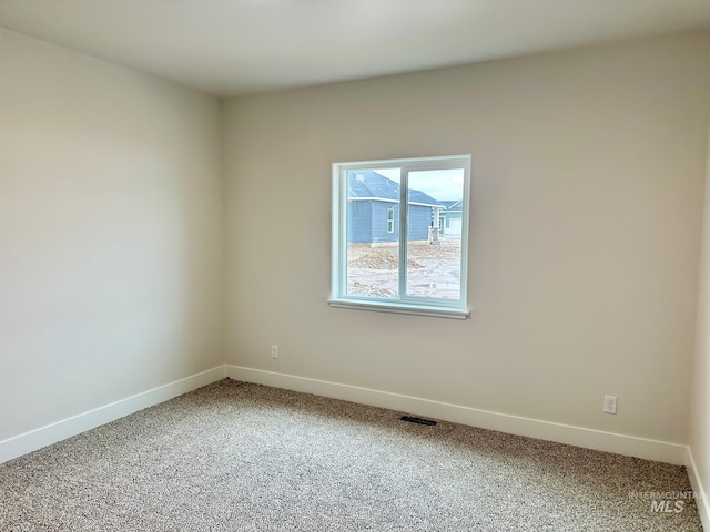 carpeted empty room with visible vents and baseboards