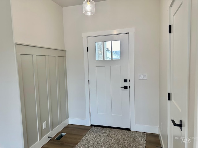 foyer entrance with visible vents, baseboards, and dark wood-style flooring