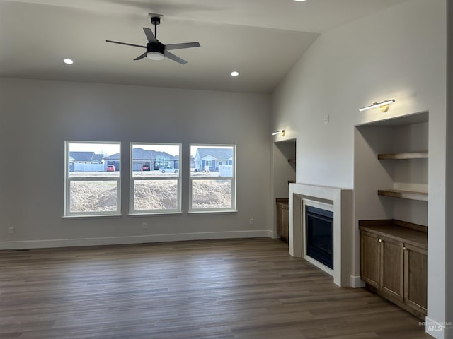 unfurnished living room featuring baseboards, recessed lighting, a fireplace, a ceiling fan, and dark wood-style flooring