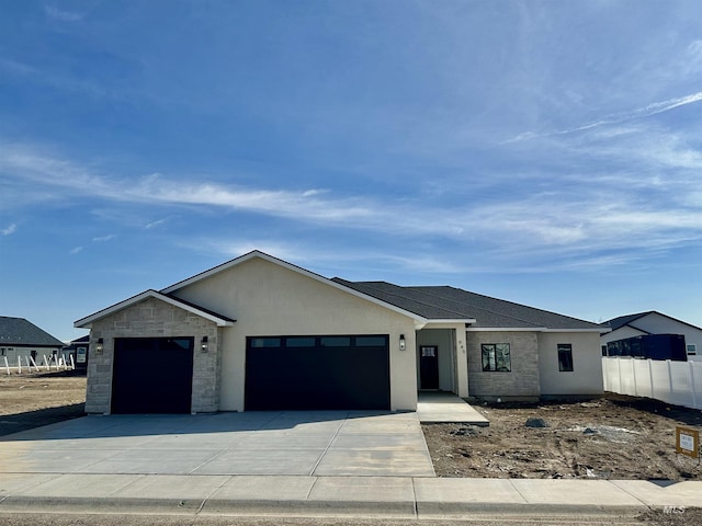 view of front of home with stone siding, stucco siding, an attached garage, and concrete driveway