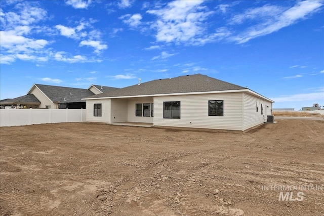 rear view of property featuring a patio area, central AC unit, and fence