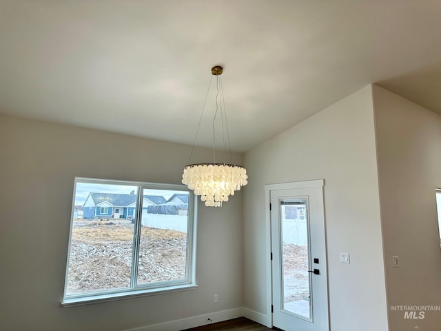 unfurnished dining area with a notable chandelier and baseboards