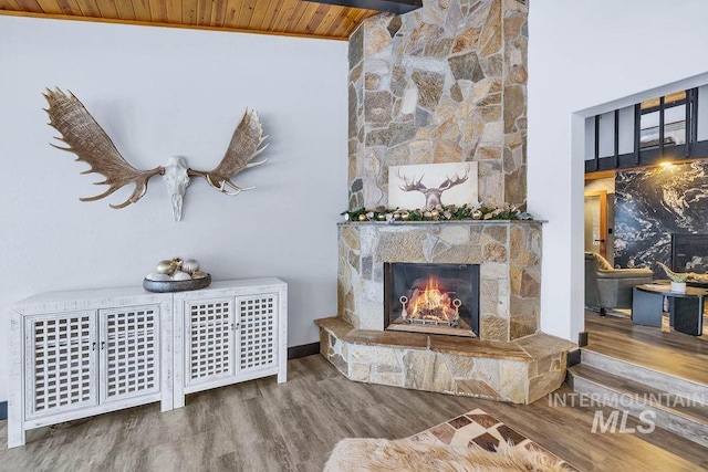 living room with wood-type flooring, wooden ceiling, a fireplace, and high vaulted ceiling