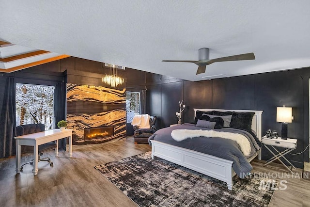 bedroom featuring wood-type flooring, a textured ceiling, and ceiling fan