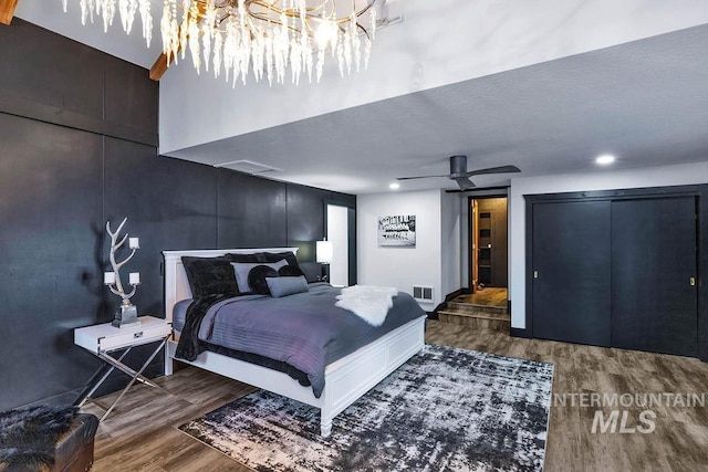 bedroom with ceiling fan, dark hardwood / wood-style flooring, and a textured ceiling