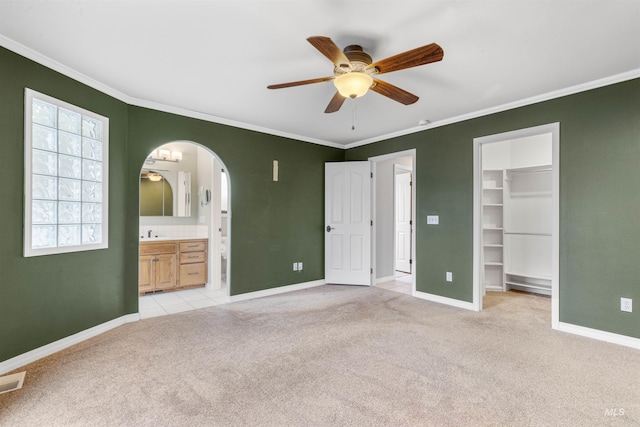 3224 Meadowlark, Lewiston, ID 83501 - unfurnished bedroom with light carpet, a walk in closet, crown molding, baseboards, and arched walkways