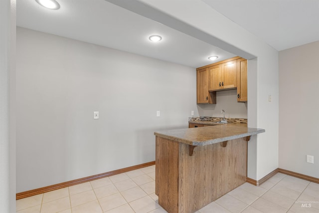 3224 Meadowlark, Lewiston, ID 83501 - kitchen with a peninsula, a kitchen breakfast bar, baseboards, a sink, and recessed lighting