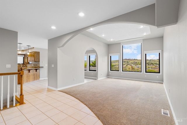 3224 Meadowlark, Lewiston, ID 83501 - unfurnished living room featuring light colored carpet, recessed lighting, arched walkways, baseboards, and light tile patterned flooring