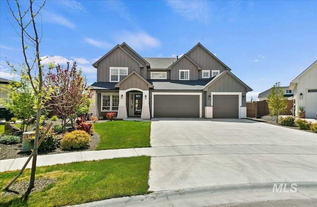 craftsman-style home featuring board and batten siding, driveway, fence, a front lawn, and an attached garage