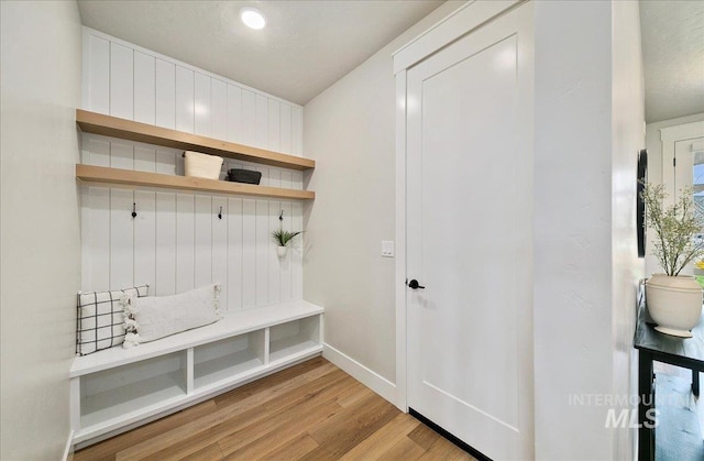 mudroom featuring baseboards and light wood finished floors