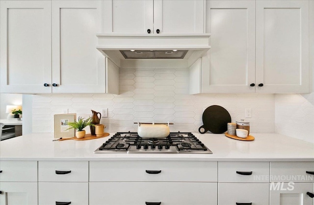 kitchen with light countertops, white cabinets, stainless steel gas cooktop, and premium range hood