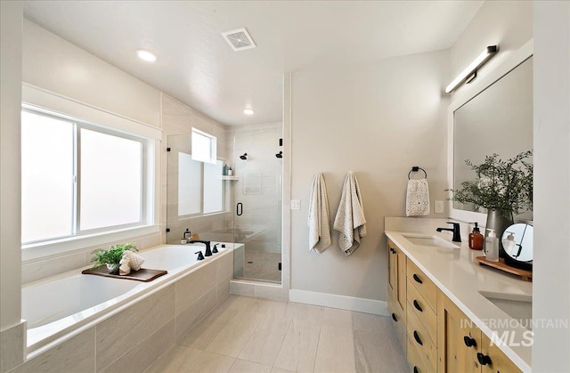 bathroom with a sink, double vanity, baseboards, a bath, and a stall shower