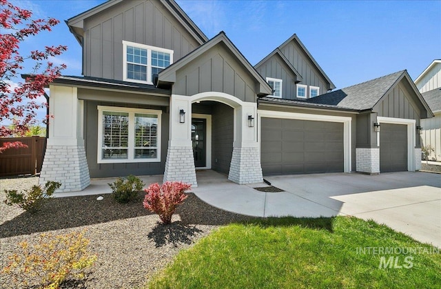 view of front facade with a garage, fence, brick siding, board and batten siding, and concrete driveway