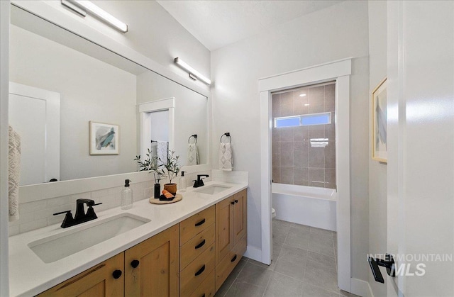 full bathroom featuring double vanity, toilet, tile patterned floors, and a sink