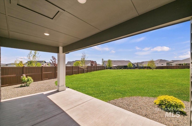 view of yard with a fenced backyard, a patio, and a residential view