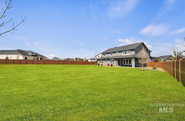 back of house featuring a fenced backyard and a yard