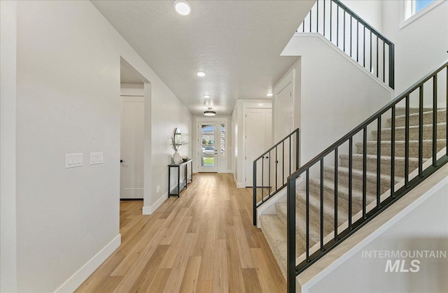 interior space featuring stairway, baseboards, recessed lighting, and light wood finished floors