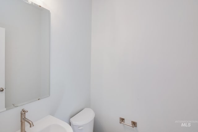 half bathroom featuring toilet and a sink
