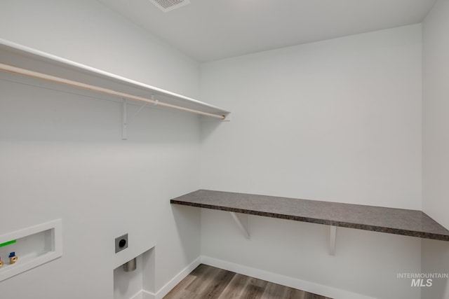 laundry area featuring wood finished floors, laundry area, electric dryer hookup, baseboards, and hookup for a washing machine