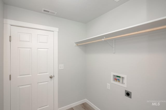 clothes washing area with hardwood / wood-style flooring, hookup for a washing machine, and electric dryer hookup