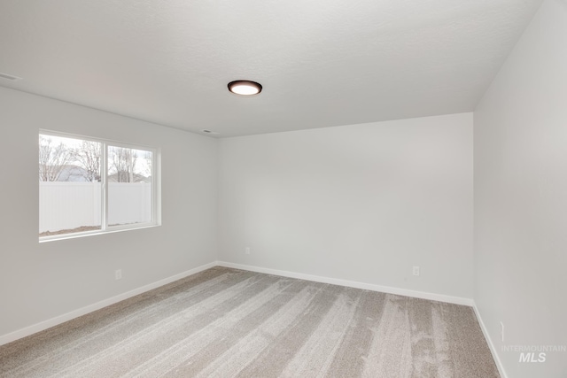 carpeted empty room featuring a textured ceiling