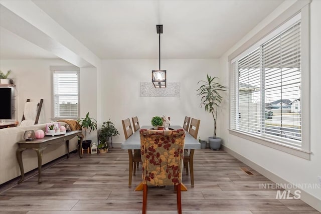 dining area featuring light wood-style floors and baseboards