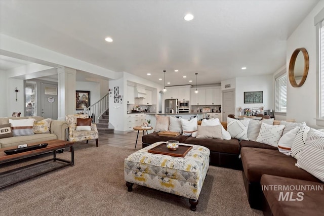 living area with recessed lighting, wood finished floors, and stairs