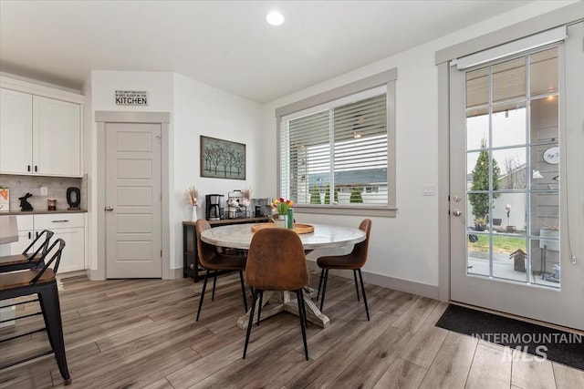 dining space with light wood finished floors and baseboards