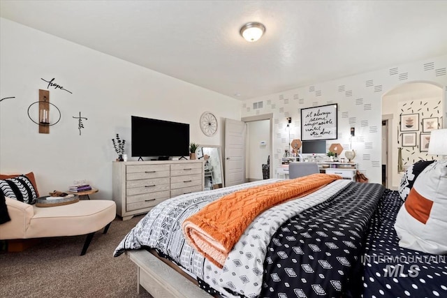 bedroom featuring arched walkways and carpet
