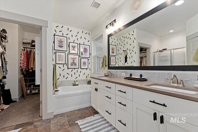 full bathroom featuring a bath, visible vents, a sink, and a stall shower