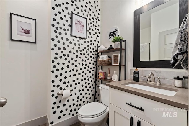bathroom featuring tasteful backsplash, vanity, and toilet