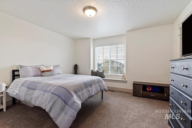 carpeted bedroom with baseboards and a textured ceiling
