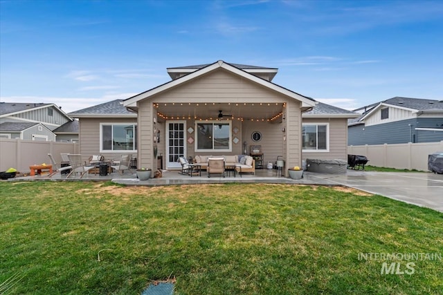 rear view of property with a yard, an outdoor living space, and fence