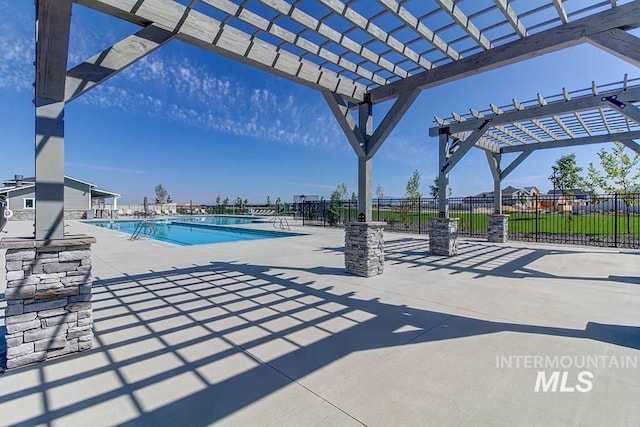 pool with a pergola, fence, and a patio area