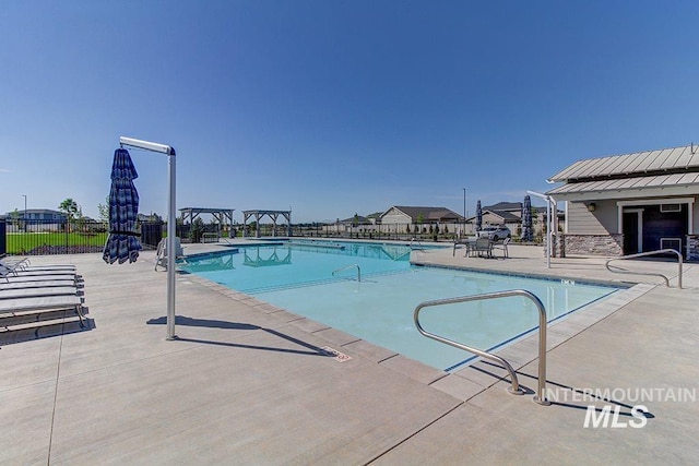 pool with a patio and fence