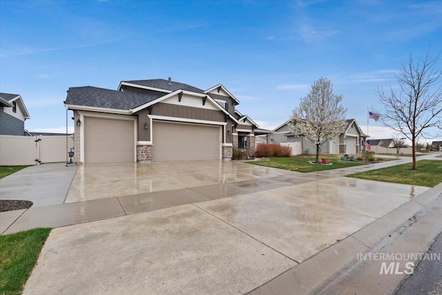 view of front of home featuring stone siding, a front lawn, a gate, an attached garage, and concrete driveway