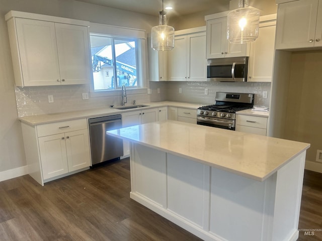 kitchen featuring decorative backsplash, dark wood-style flooring, stainless steel appliances, white cabinetry, and a sink