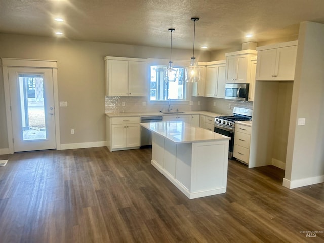 kitchen featuring dark wood-style floors, appliances with stainless steel finishes, a sink, and tasteful backsplash