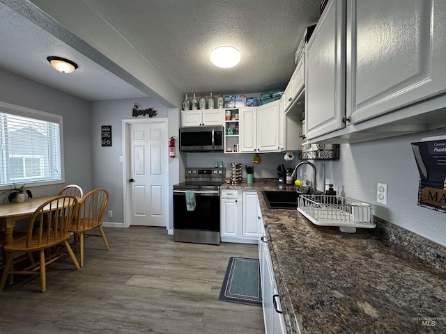 713 California St, Gooding, ID 83330 - kitchen featuring stainless steel appliances, a sink, a textured ceiling, open shelves, and light wood-style flooring