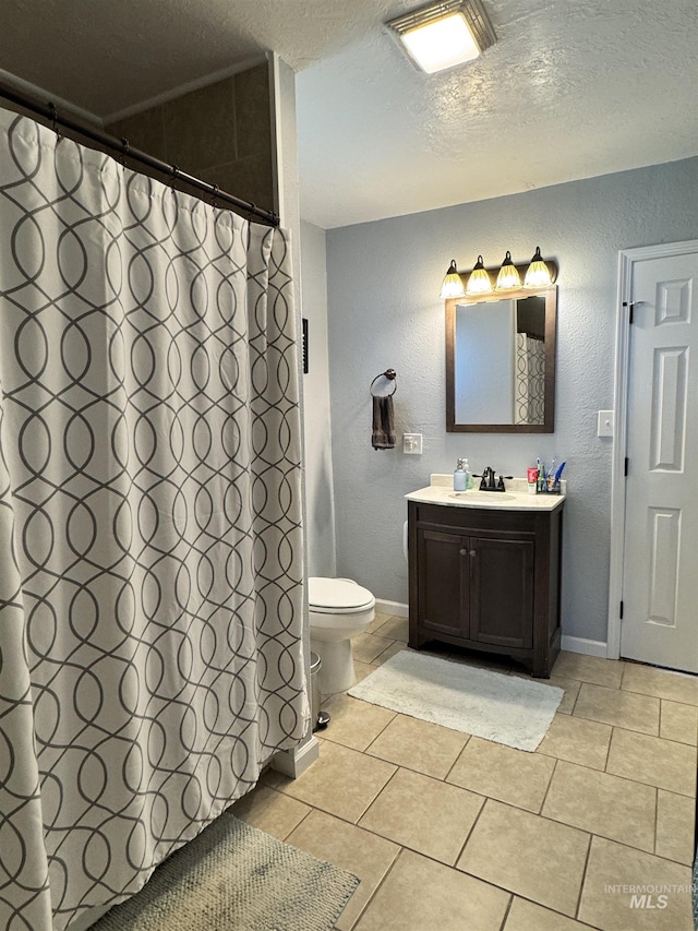 713 California St, Gooding, ID 83330 - bathroom with toilet, a textured ceiling, vanity, a textured wall, and tile patterned floors