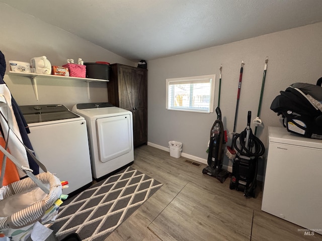 713 California St, Gooding, ID 83330 - laundry room featuring independent washer and dryer, cabinet space, light wood-style floors, and baseboards