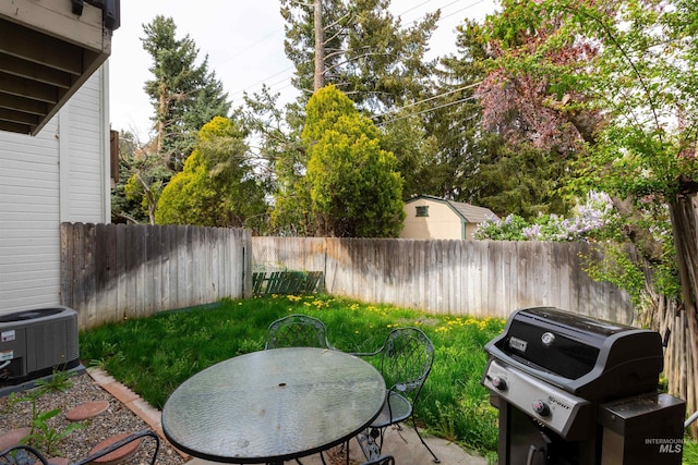 view of yard with a fenced backyard, a patio area, central air condition unit, and outdoor dining space