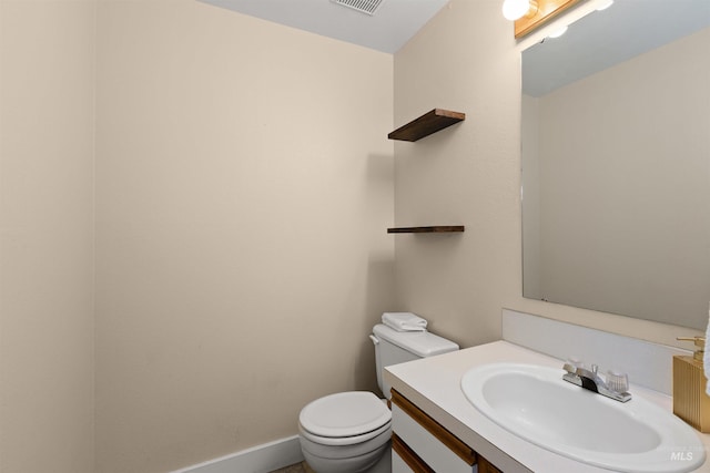 half bath featuring vanity, toilet, and visible vents