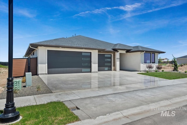 8506 W Graye St, Meridian, ID 83646 - prairie-style home featuring a garage, concrete driveway, a shingled roof, and stucco siding