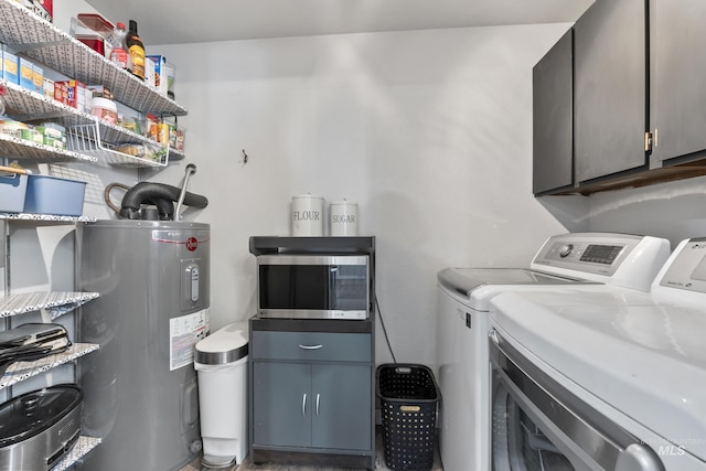 laundry area featuring washer and clothes dryer, cabinet space, and water heater