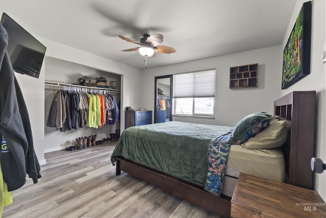 bedroom featuring baseboards, a ceiling fan, a closet, and wood finished floors
