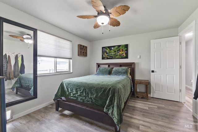 bedroom featuring baseboards, a ceiling fan, and wood finished floors
