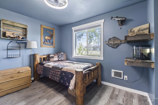 bedroom with baseboards and wood finished floors