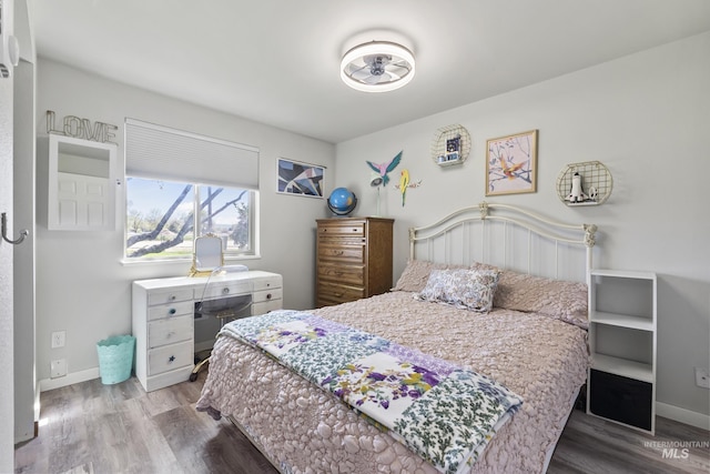 bedroom featuring baseboards and wood finished floors