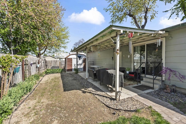 view of yard featuring a storage shed, an outdoor hangout area, a fenced backyard, entry steps, and a patio area